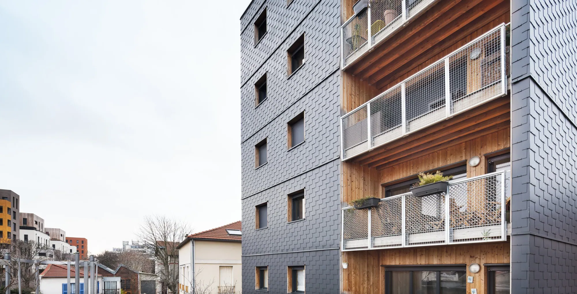 Façade en ardoise et balcons en bois de Black Sun
