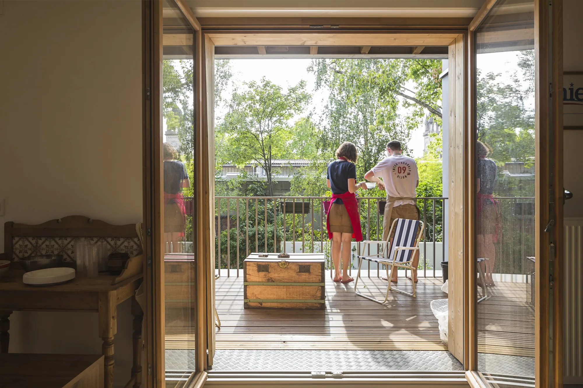Porte-fenêtre ouverte sur un balcon en bois