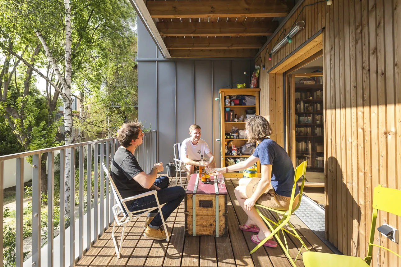 Repas entre voisins sur une loggia en bois